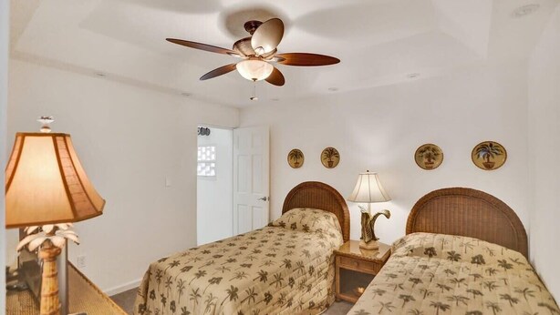 A hotel room with two beds, a ceiling fan, a lamp, and wall decorations. - Fort Lauderdale Yacht & Beach Club 411 (Fort Lauderdale)