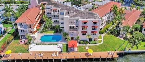 Un hotel de varios pisos con piscina, un muelle y vistas del entorno.