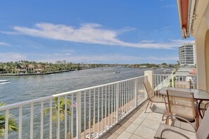 Ein Balkon mit Blick auf einen Fluss, eine Stadtlandschaft und einen klaren Himmel.