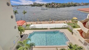 A swimming pool with a view of a marina and buildings across the water.
