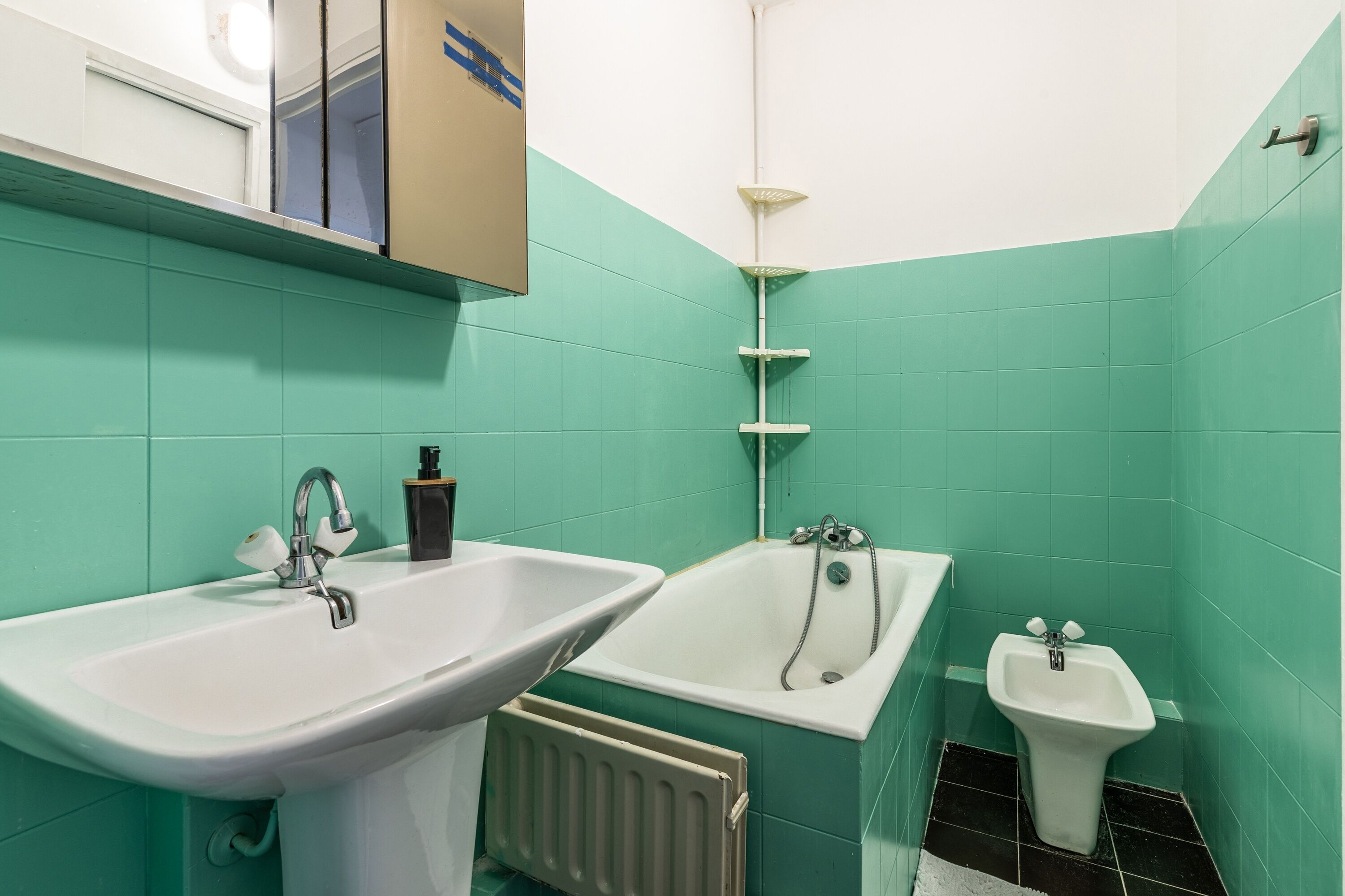 Un baño con lavabo, bañera y lavamanos pedestal.