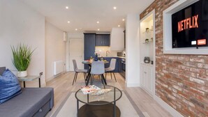 A modern apartment with a dining area, kitchen, and a living room with a sofa and coffee table. - York Luxury Apt: Bishopthorpe Rd 2, Sleeps 6 (York)