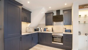 A modern kitchen with dark cabinets, a built-in oven, and a microwave. - York Luxury Apt: Bishopthorpe Rd 2, Sleeps 6 (York)
