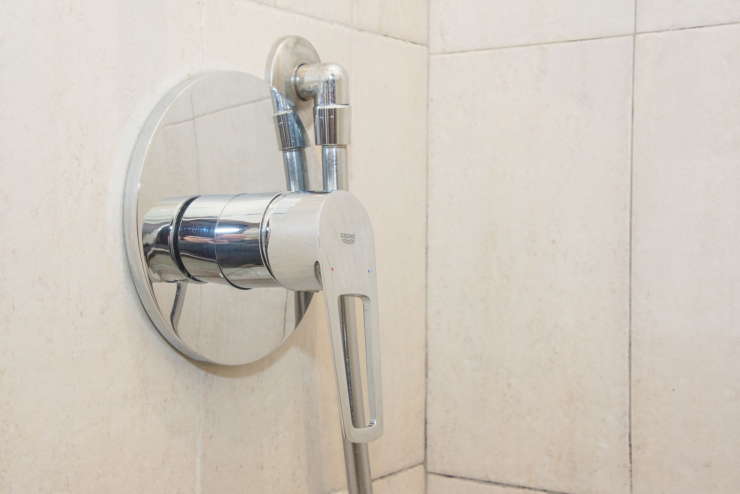 A chrome showerhead mounted on a tiled wall.