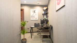 A small office space with a desk, chair, computer, and a potted plant. - Rometobe Rooms & Hospitality (Rome)