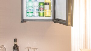 A refrigerator with various beverages and a wine bottle. - Rometobe Rooms & Hospitality (Rome)