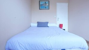 Una camera da letto con un letto, una porta e un quadro appeso al muro.