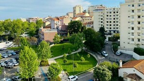 Un quartiere residenziale caratterizzato da edifici a più piani, un parco verde e un parcheggio.