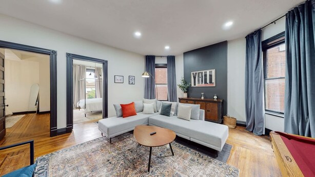 A modern living room with a sectional sofa, a small coffee table, and a pool table. - Pool Table|King Beds|0.6 miles from UofL|Downtown (Louisville)