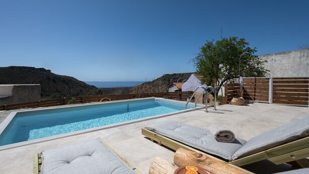 A pool area with lounge chairs and a view of the sea. - Nomas  Skaloti House (Skaloti)