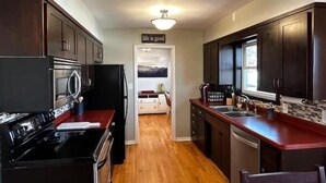 A kitchen with dark wooden cabinets, stainless steel appliances, and a wooden floor. - Golf view! (Red Wing)