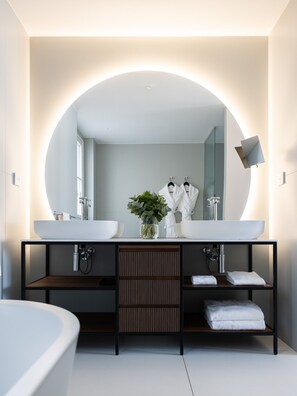 A modern bathroom with a large mirror, two sinks, a plant, and a bathtub. - 1.75 Paris La Source (Paris)