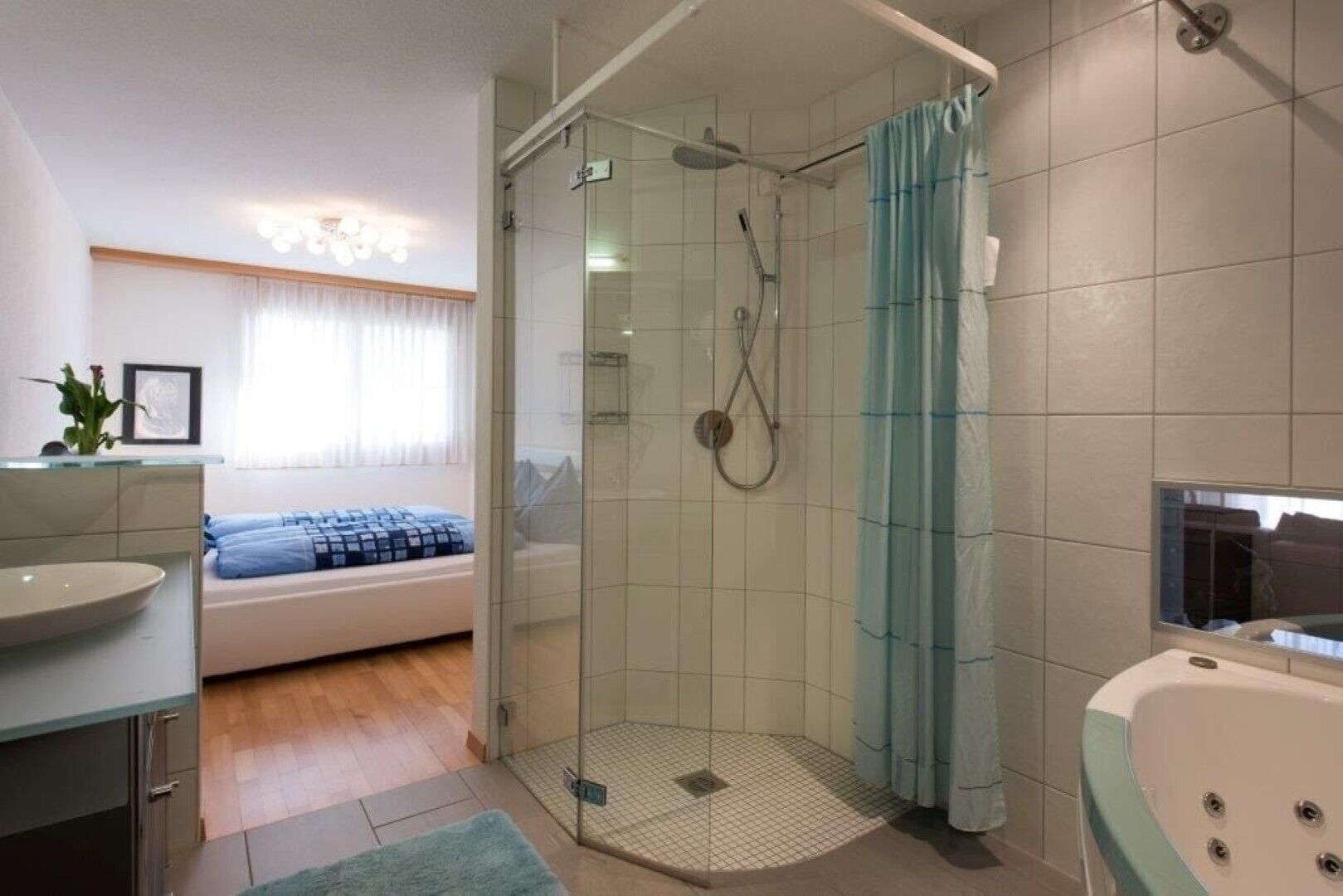 Une salle de bain moderne avec une douche à parois de verre, une baignoire et une fenêtre avec des rideaux.
