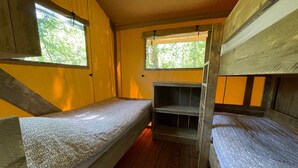 Habitación pequeña con dos literas, paredes de madera y ventanas que dejan entrar luz natural.