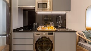 Une cuisine compacte équipée d’un four à micro-ondes, d’un évier et d’un lave-linge.