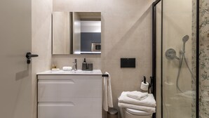 Une salle de bain moderne équipée de toilettes, d’un lavabo et d’une douche.