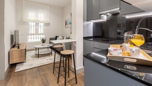 A modern kitchen with a black countertop, stainless steel appliances, and a breakfast tray with orange juice.