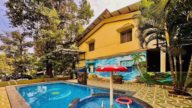 A swimming pool with a circular hot tub, surrounded by a patterned tile floor and a mural of a beach scene. - Rajdhani Resort Lonavala (Mawal)