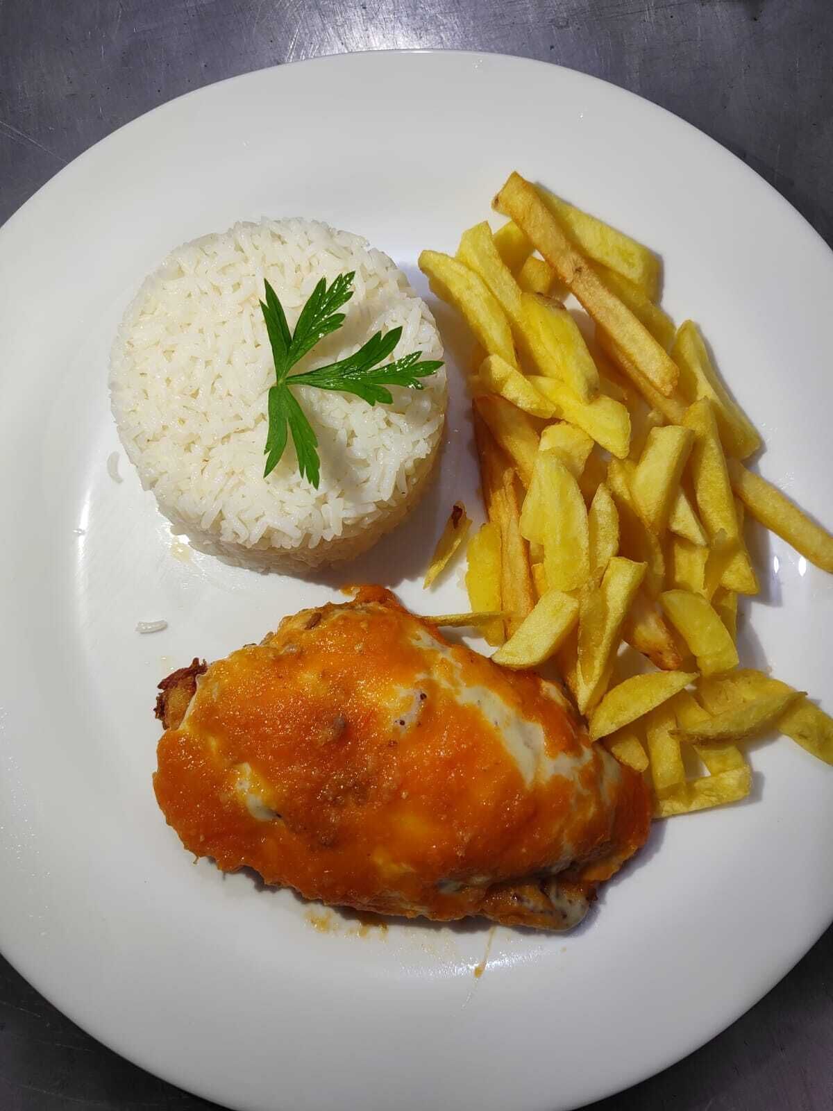 Un plato con arroz blanco, papas fritas y un trozo de pollo frito.