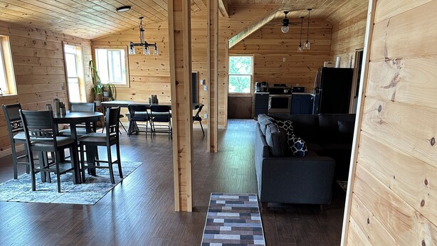 Un intérieur spacieux en bois, comprenant un coin repas, un canapé et une cuisine.