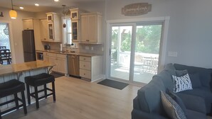 Una cocina moderna con armarios de madera, una isla central y un comedor con taburetes negros.