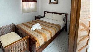 A small, neatly arranged bedroom with a single bed, a chair, a mirror, and a curtain. - Family Riad in Marrakech for 6 people (Marrakech)