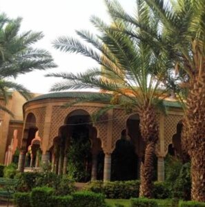 Stroll through a tranquil courtyard surrounded by lush greenery and palm trees, featuring a series of arches with a historic charm.