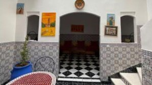 A room with a checkered floor, a potted plant, and a painting on the wall. - Family Riad in Marrakech for 6 people (Marrakech)