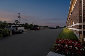 A parking lot with a white pickup truck and a red sedan. - Suburban Studios (Coraopolis)