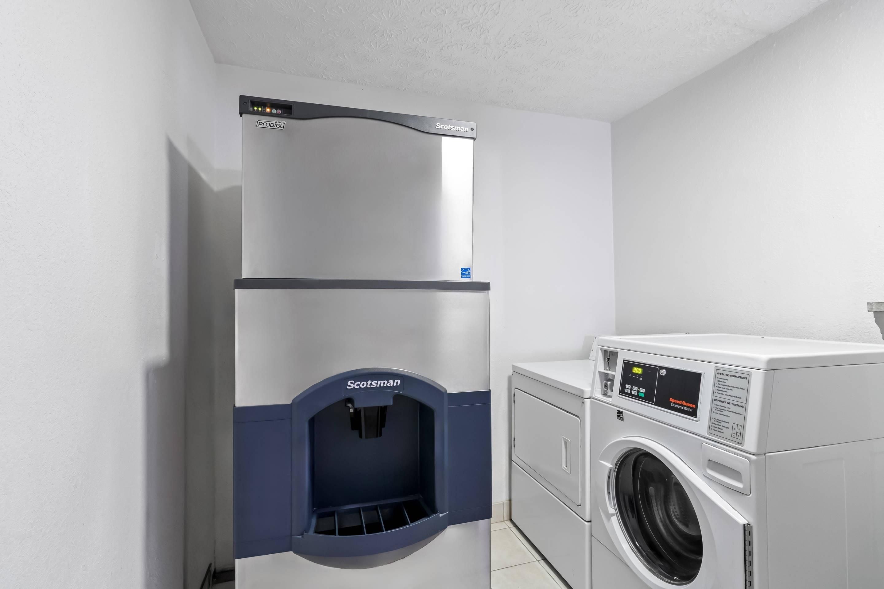 A laundry area with a Prodigy water dispenser and a Scotsman washing machine.