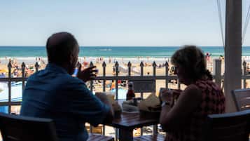 Een restaurant aan het strand met uitzicht op de oceaan.