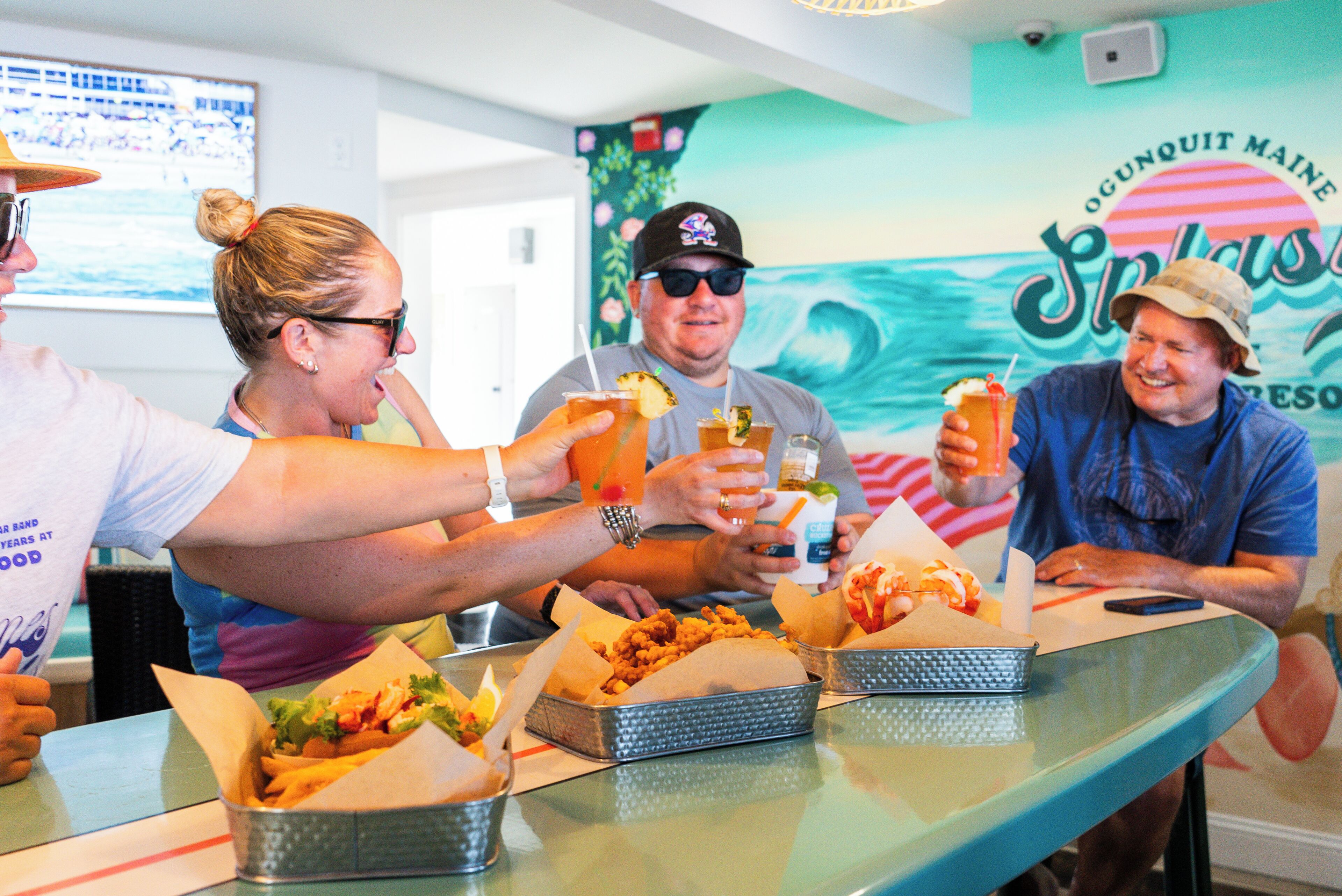 A group of people dining at a restaurant with seafood dishes and drinks.