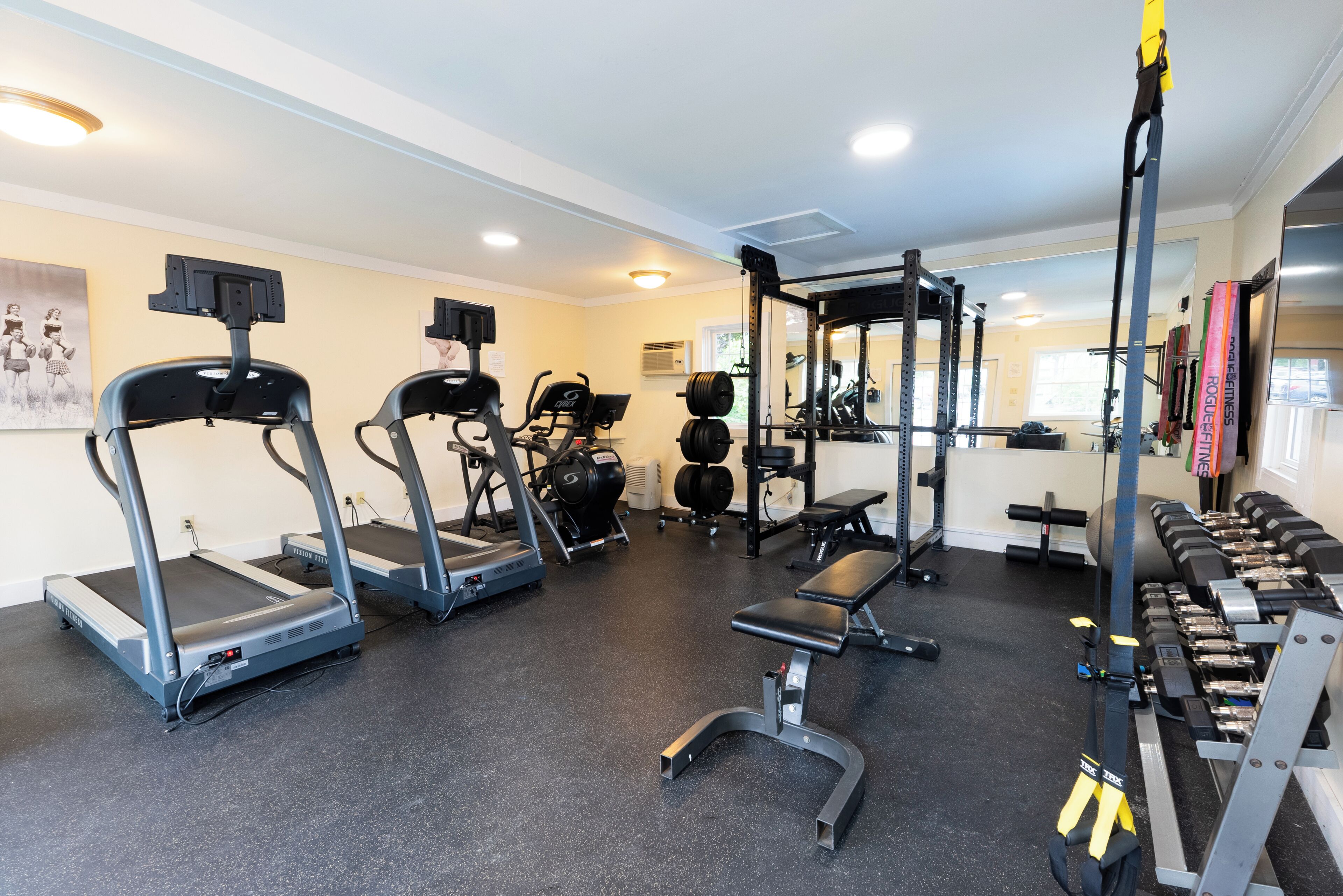 A gym with treadmills, weight benches, and various exercise equipment.