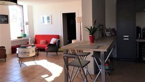 A modern living room with a red sofa, a coffee table, and a dining area with a table and chairs.