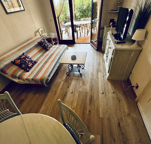 A compact room with a bed, a small table, a TV, and a kitchenette. - Bright cocoon in Sainte-Maxime - close to the sea (Sainte-Maxime)