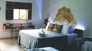 A bedroom with a bed, a desk, and a chair.