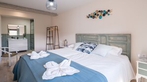 A hotel room with a bed, a nightstand, a mirror, a wardrobe, and a wall art piece. - The Moradel Moncayo  (Añón de Moncayo)