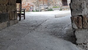 An arched stone structure with a bench and a building in the background. - The Moradel Moncayo  (Añón de Moncayo)
