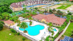 Ein Resort mit großem Schwimmbad, mehreren Gästehäusern und üppiger Bepflanzung.