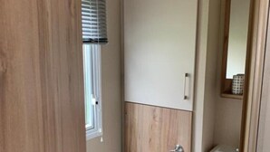 Un baño pequeño con inodoro, lavamanos y puerta de madera.