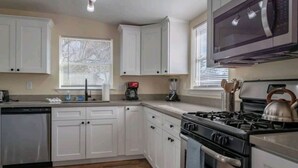 A kitchen with white cabinets, a stove, a microwave, and a dishwasher. - Downtown Paso Wine Country Retreat/2bd/2ba/Walk to the Market Walk/Downtown/Fair (Paso Robles)