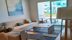 Una sala de estar moderna con un sofá, una mesa de centro y un cuadro en la pared.