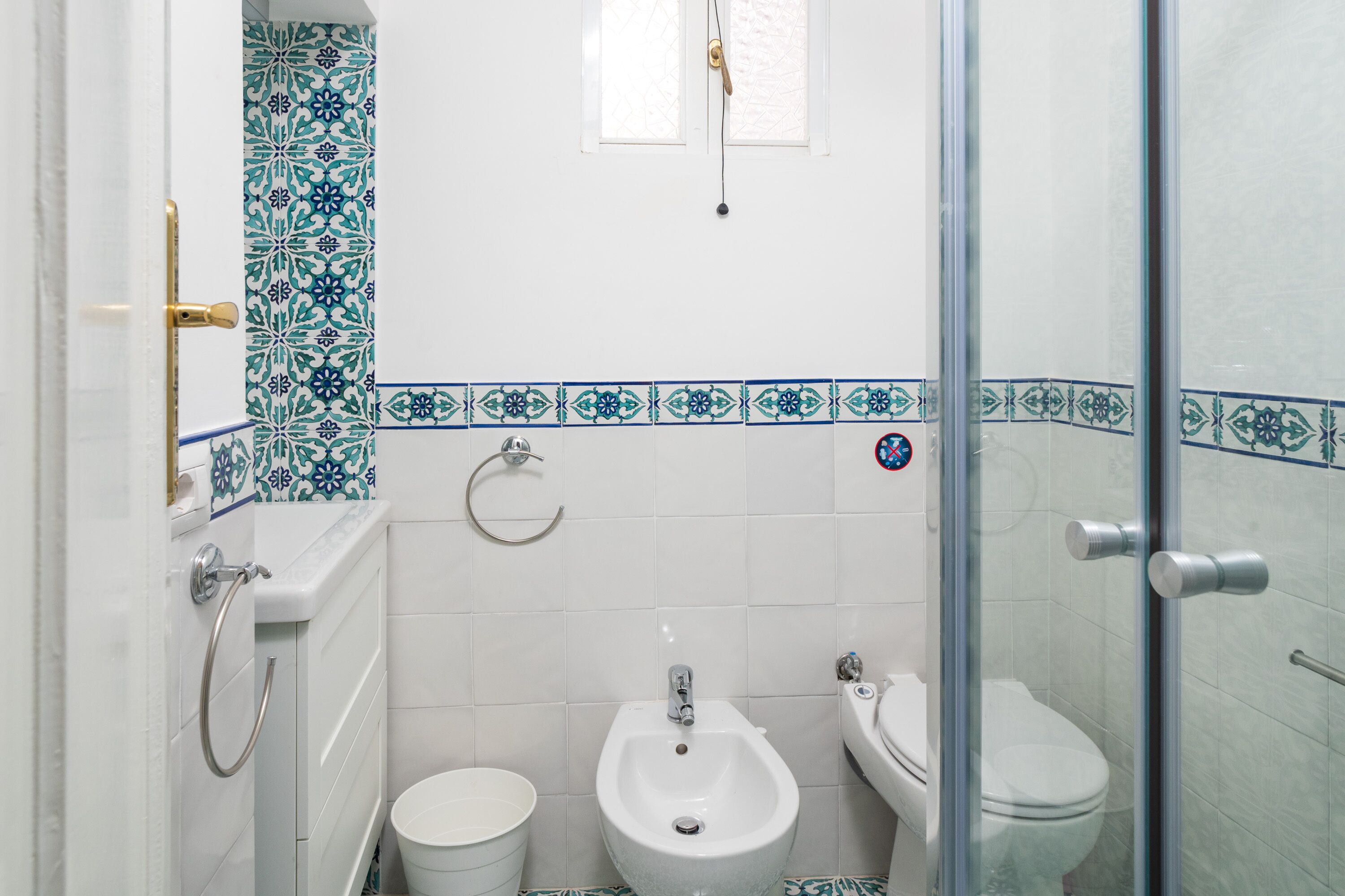 Un baño con bidé, inodoro y cabina de ducha de cristal.