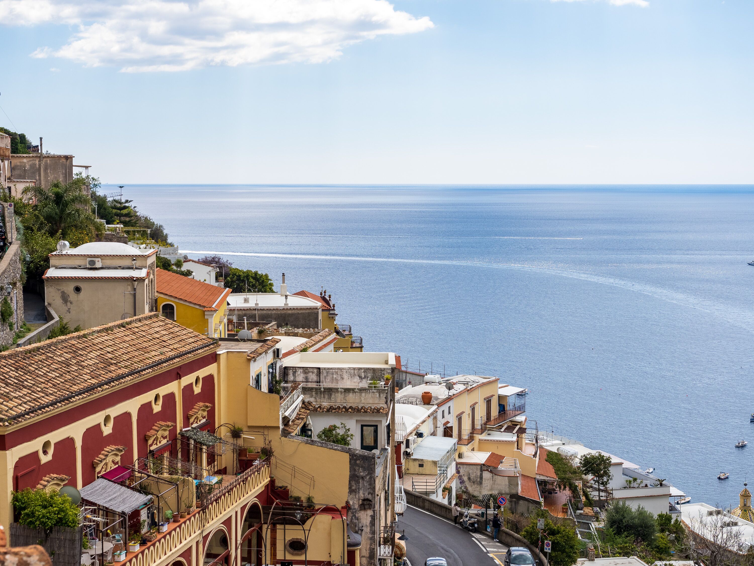 A coastal town with buildings along a street overlooking the sea.