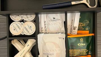 Un cajón con bolsitas de té, un par de tijeras y una olla de acero inoxidable.