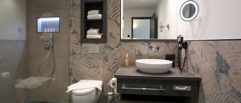 A modern bathroom with a toilet, sink, and shower.