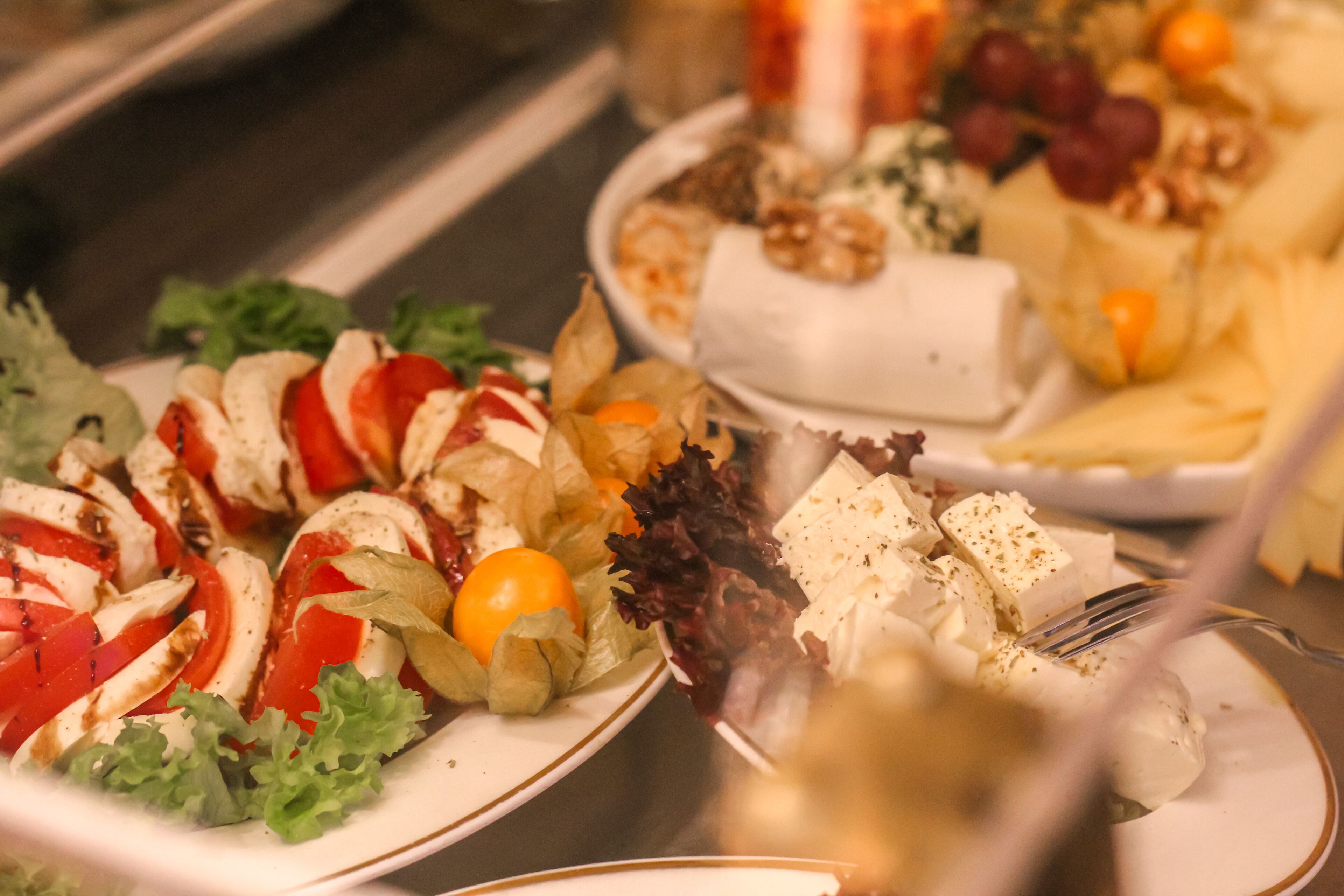 A buffet with various dishes including salads, cheeses, and fruits.