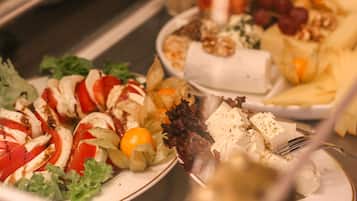 A buffet with various dishes including salads, cheeses, and fruits.