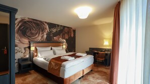 A hotel room with a large bed, a desk, and a chair. - SPREE. Hotel am Hafen (Lübbenau/Spreewald)