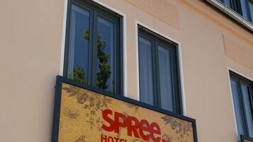 A hotel sign with the name 'SPREE HOTEL AM HAFFEN' on a building facade.